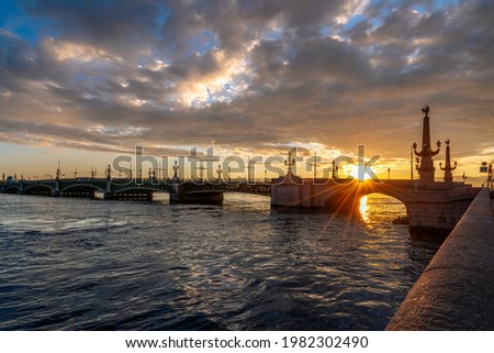 View of the Trinity Bridge over the Neva River in the first rays of the rising sun on a summer morning, St. Petersburg, Russia