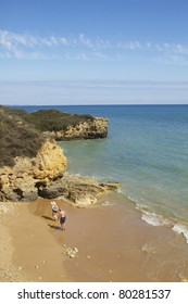 View Of Two Older Couple Walking On The Beach.