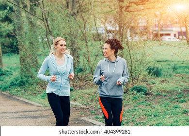 View Of Two Women Running Together In The Park