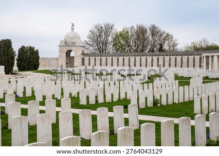 View of the Tyne Cot Memorial featuring a domed pavilion and rows of white Commonwealth headstones. Located in Zonnebeke, it is the world's largest British military cemetery, honoring WWI fallen in Flanders, Belgium. UNESCO World Heritage site.