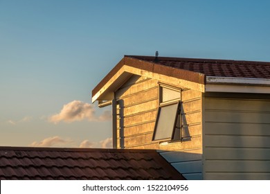 View Of Typical New Zealand Suburban House With Weatherboard Cladding Wall, Concrete Tile Roof And Awning Window