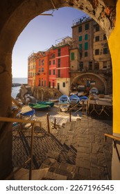 View from under an arch of boats in the fishing village of Riomaggiore. Cinque Terre National Park, Liguria region, Italy, Europe.