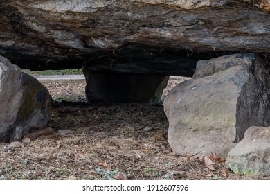 View under a dolmen capstone sitting on smaller boulders.