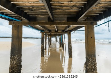 View under of wooden pier bridge Extending into the Sea, Embracing Thailand's Eastern Island's Rocky Shores as day time. - Powered by Shutterstock