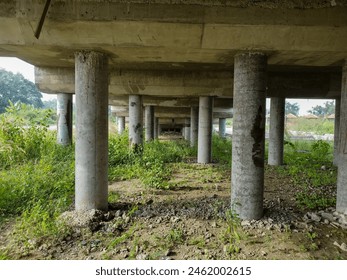 view of the underside of a bridge made of sturdy concrete, taken during the day