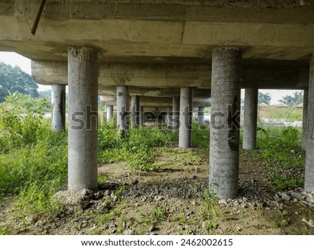 view of the underside of a bridge made of sturdy concrete, taken during the day