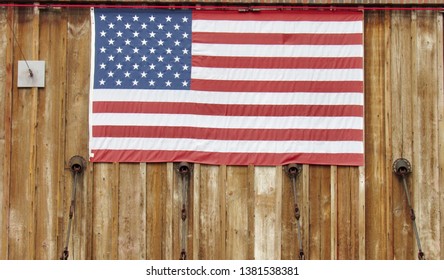 View of United States American flag hanging on a rustic wood background