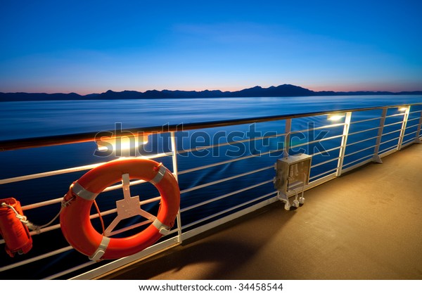 View from the upper deck of a cruise ship sailing\
in Alaska at dusk.