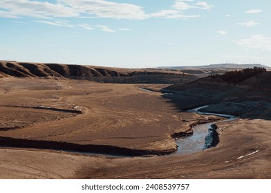 View of the upper oldman river running through the nearly empty Oldman Reservoir in Alberta, Canada. Photo taken December 2023 during which the Reservoir has reached historic lows. 