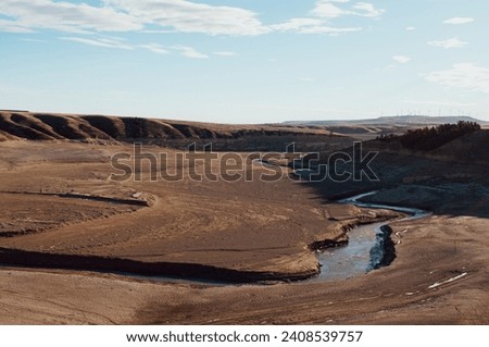 View of the upper oldman river running through the nearly empty Oldman Reservoir in Alberta, Canada. Photo taken December 2023 during which the Reservoir has reached historic lows. 