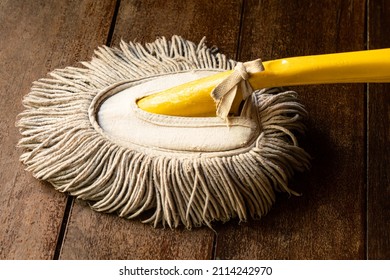 View of used handy mop on wooden floor. Handy mop is use to clean dust on the office table.