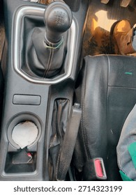 A view of various interior elements in a car, highlighting the manual gear shift, handbrake, and other console details.