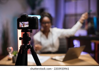 View Of Video Camera Screen With Attractive Confident African American Skilled Business Woman Explaining Online Economic Charts On Glass Board To Her Colleagues.