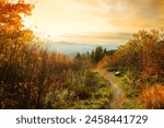 View from a viewing point in the autumn mountains to the tops of mountain ranges and the forest at sunset. Cozy bench with a view of the mountains. Vermont. USA.