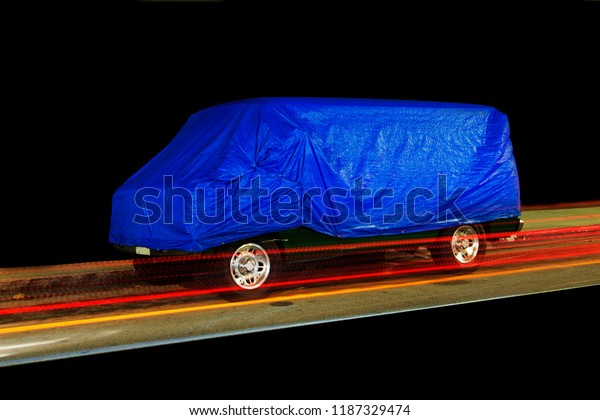 A view of a vintage van car and light trails\
in a black background