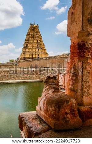 View of Virupaksha temple main gopuram or gopura with Nandi and lake in hampi karnataka india. unesco world heritage site