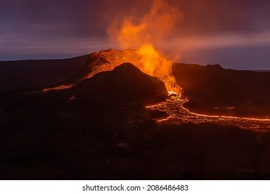View of volcanic eruption in Iceland. Crater from the volcano Fagradalsfjall at night to the blue sky with liquid lava. Volcano on the Reykjanes peninsula in the GeoPark.
