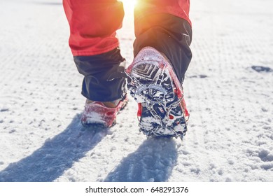 View Of Walking On Snow With Snow Shoes And Shoe Spikes In Winter. Vintage Tone.