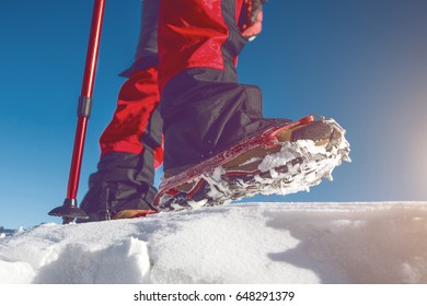 View Of Walking On Snow With Snow Shoes And Shoe Spikes In Winter. Vintage Tone.