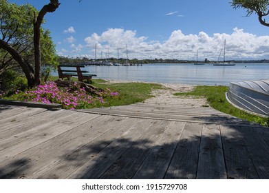 A view from the walking track along Raymond Island showing boats, flowers and a sunny day.