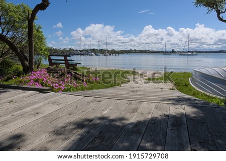 A view from the walking track along Raymond Island showing boats, flowers and a sunny day.