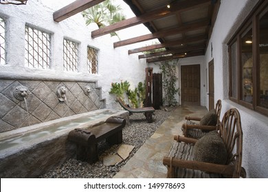 View Of Water Feature By Armchairs Along Pathway