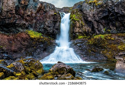 View of the waterfall in the mountains. Waterfall on mossy rocks. Mountain waterfall view. Waterfall view