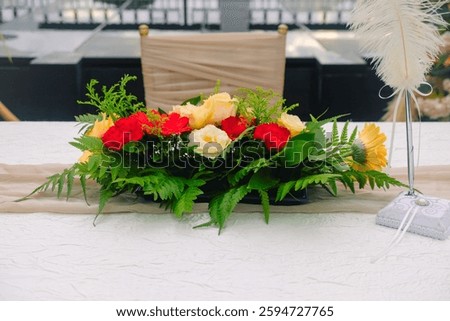 View of wedding solemnisation table setting, beautiful flower bouquet in centre with quill pen at the side for signing during the ceremony. Modern chic simple decor.