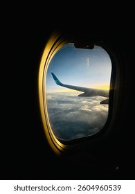 View while flying above the clouds from inside the plane.
