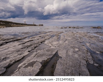 View of Whitby East Pier from the rocks on the East Beach at low tide - Powered by Shutterstock