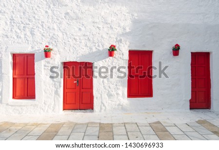 View of white street and flowers in Bodrum city of Turkey. Aegean style colorful street, wall, house and flowers in Santorini, Mykonos / Greece. White wall, red doors and flowers.