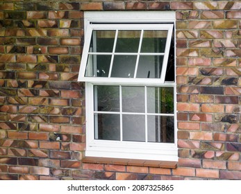 View Of White Wooden Divided Awning Window On Brick Wall