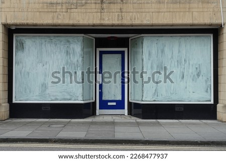 View of whitewashed windows of a foreclosed business on a street