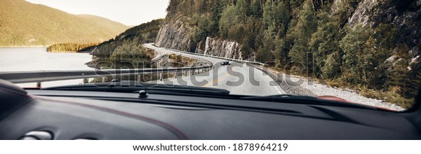 A view of a winding road and a super car from a\
running sports car