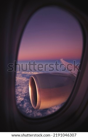View from window of airplane during night flight above ocean. Selective focus on jet engine.
