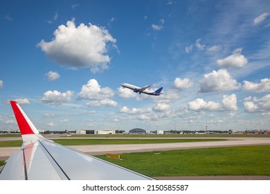 View from the window of an airplane, on a plane taking off, over a beautiful cloudy sky. Airplane or airplane window with wing and cloudy sky behind