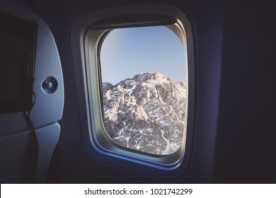 View From Window Airplane. Outside Can See Snow , Tree And Sunset. Winter Season. Natural Background. Aboard The Plane. Mountains Outside The Window Of The Plane