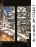 view of a window and the city lights behind at night from a hight point of view