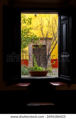 View from window inside Miguel Hidalgo House Museum showing courtyard and colonial wall