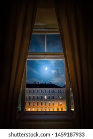 The View From The Window Of The Old Night City Of Vienna And The Moon In The Cloudy Sky.