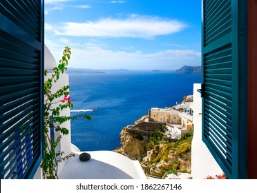 View from a window overlooking the sea, caldera and whitewashed village of Oia on the island of Santorini Greece.
