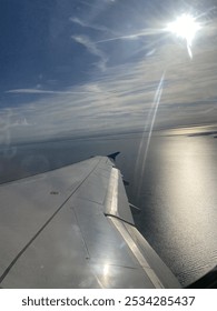 A view from the window of a plane flying over a body of water.