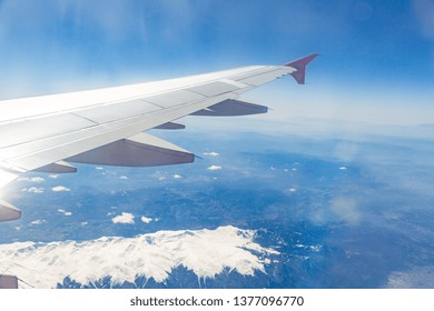 view from the window of the plane that flies over the mountains.
