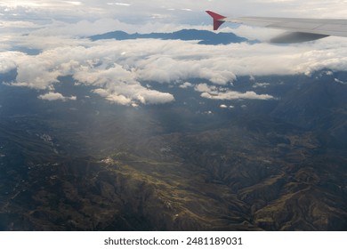 View of the wing of an airplane with a mountain range in the evening light in the background. Colombia. - Powered by Shutterstock