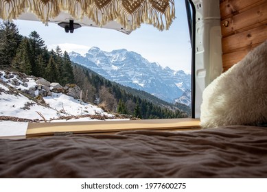 A view of a winter alpine mountain through the window of a campervan