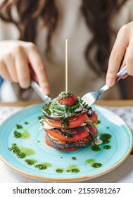 View Of Woman Eating An Aubergine And Tomato Timbale On A Plate. Delicious And Healthy Food In The Restaurant