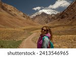 View of a woman hiking along the path that leads to mount Aconcagua in the Andes mountains. 