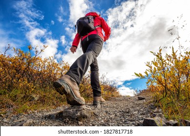 View of Woman Hiking Rocky Trail from Below during Fall in Canadian Nature. Taken in Tombstone Territorial Park, Yukon, Canada. - Powered by Shutterstock