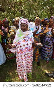 View Of A Women Meeting In The Rural Village Of Talto Djega-Saré Diallo, Kolda Region, Senegal, West Africa. October, 11, 2019. Standing Colorful Dressed African Ladies In The Countryside. 