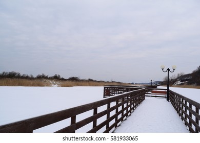 View of the wooden boardwalk on the lake in the village of AMBER in the winter